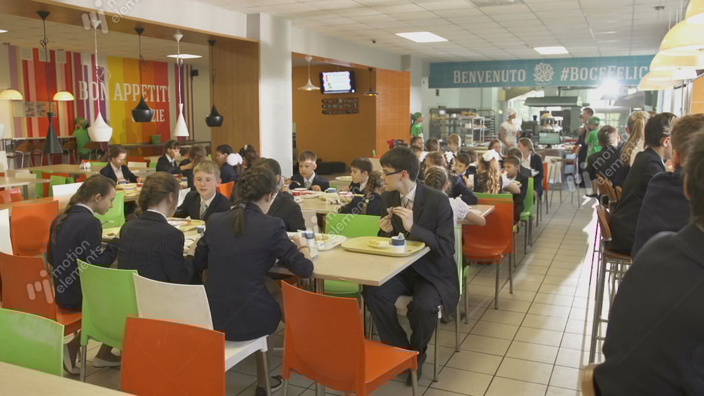 Pupils In School Uniform Sit At Tables With Lunch Stock video footage