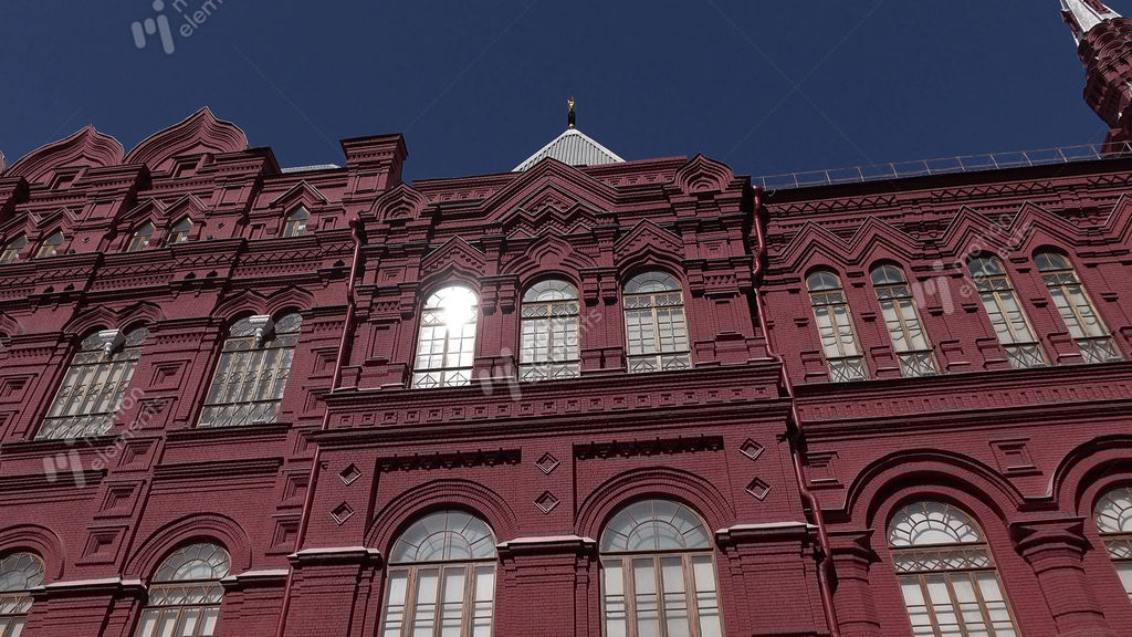 tracking shot of red brick facade with narrow arched windows