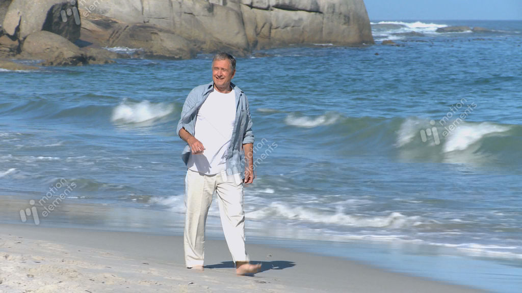 Elderly Man Walking Along The Beach Stock video footage 4543628